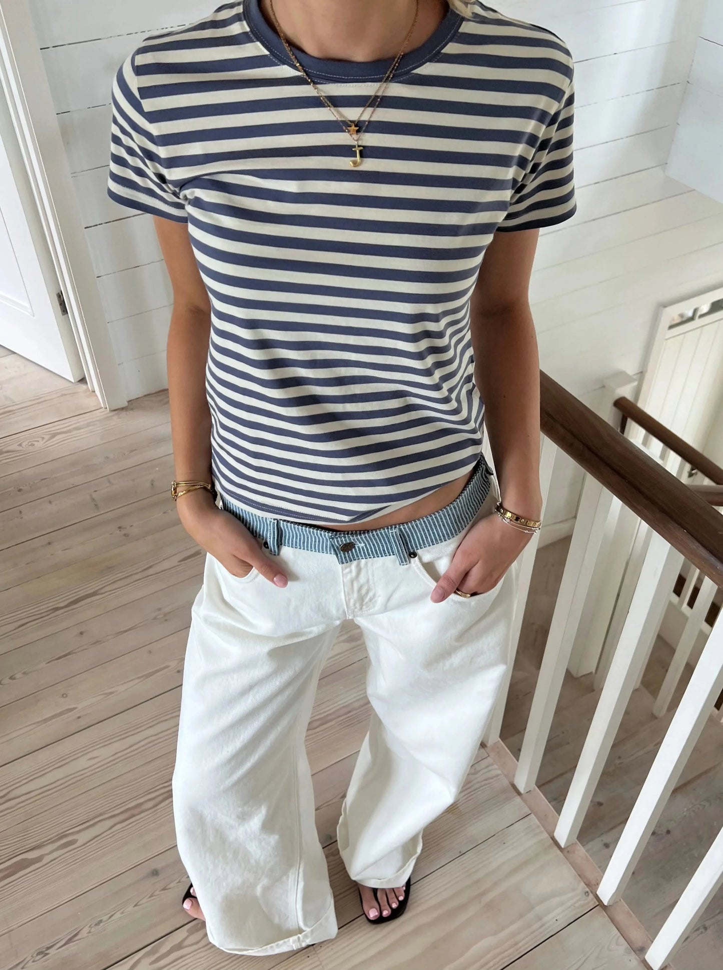 White jeans waistband close-up showing blue striped fabric and embroidered star detail