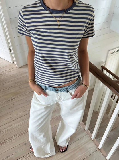 White jeans waistband close-up showing blue striped fabric and embroidered star detail
