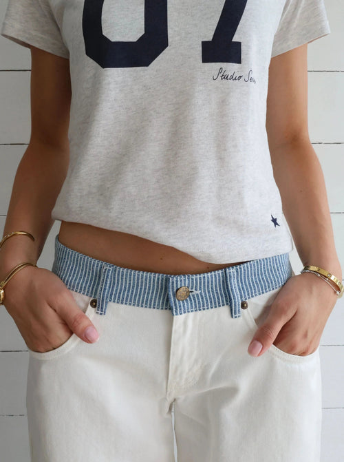 White denim jeans with blue striped waistband, front view full length