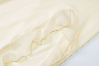 Cream fabric texture showing soft ribbed knit material detail