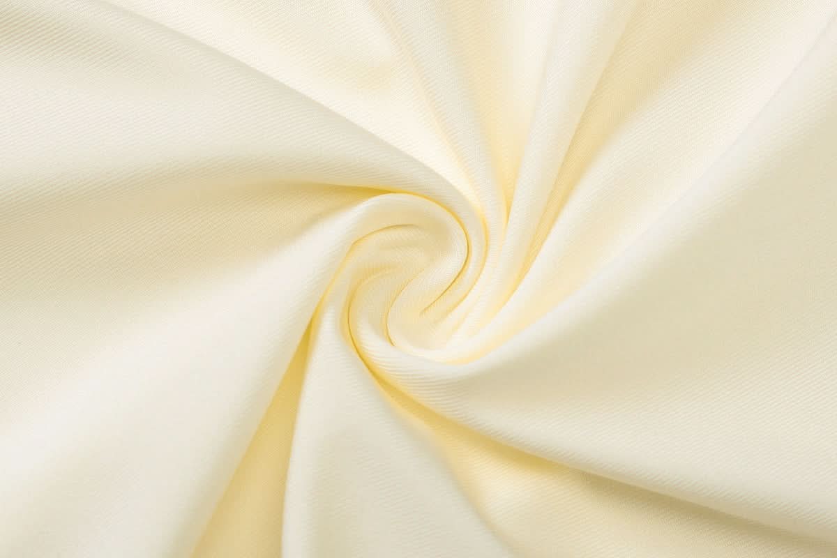 Ivory fabric close-up displaying flowing draped textile weave