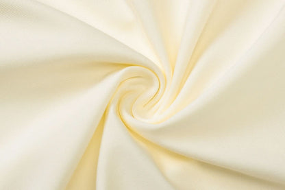 Ivory fabric close-up displaying flowing draped textile weave