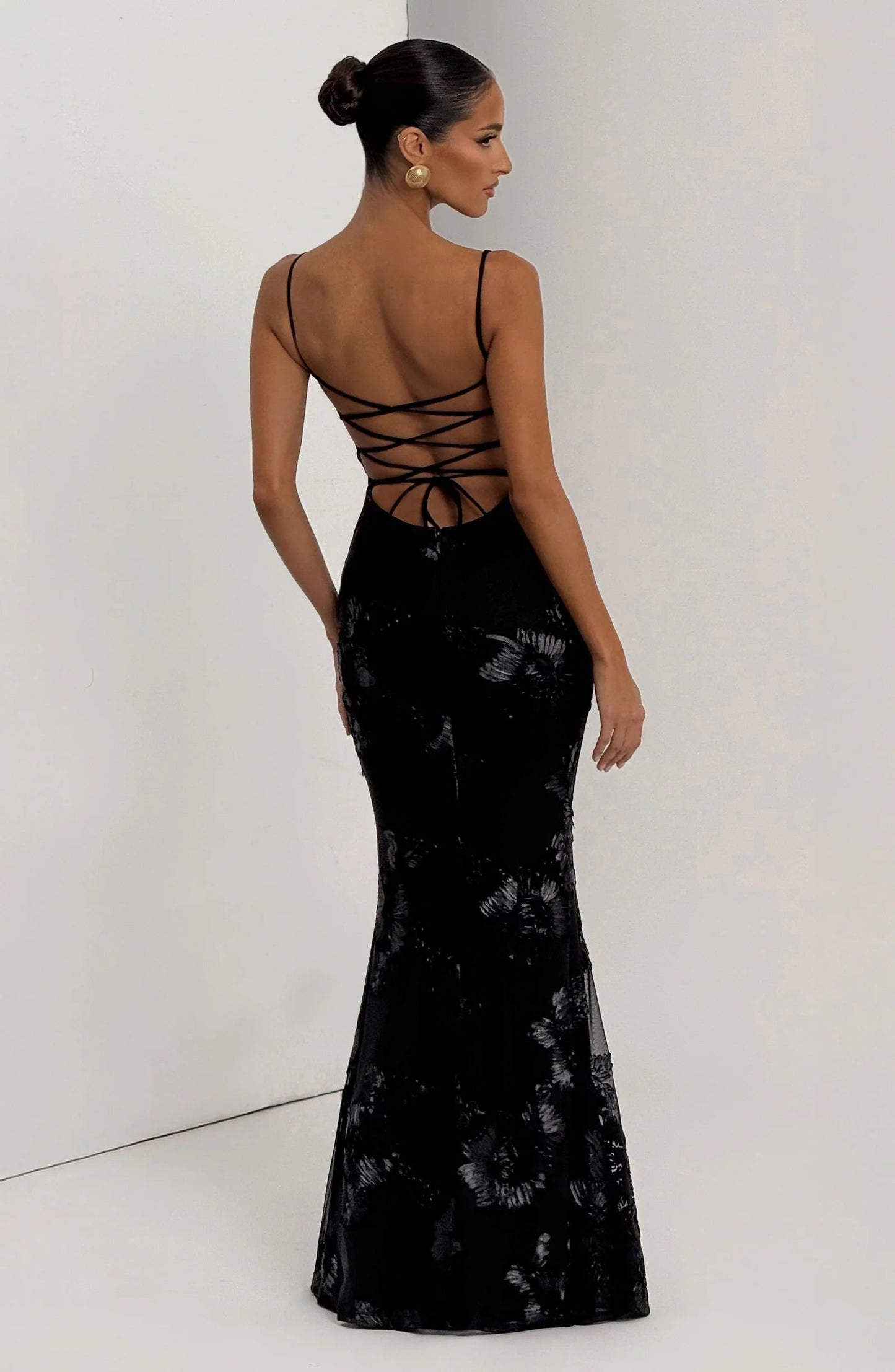 Back view of black floral maxi dress with lace-up corset detail