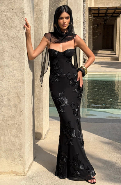 Black floral corset maxi dress worn with sheer overlay and poolside setting