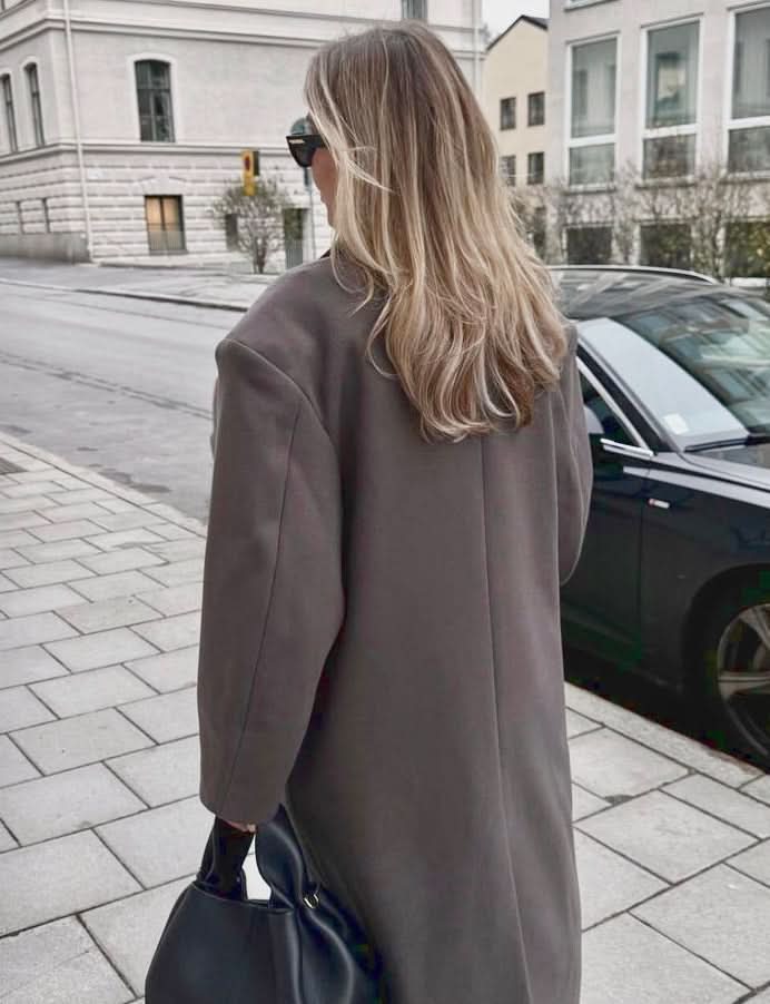 Taupe long coat back view showing relaxed fit and length