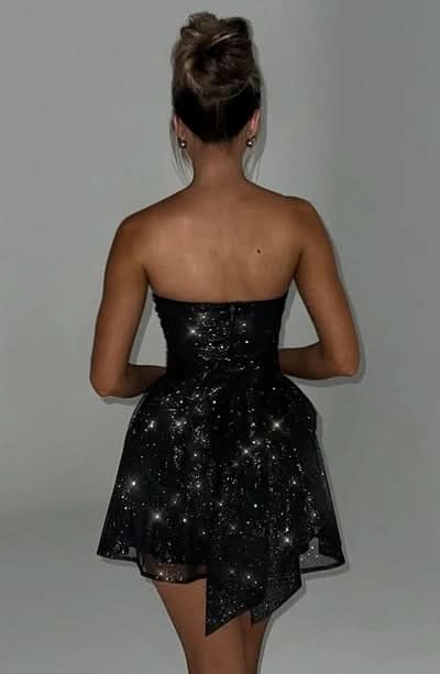 Back view of black sequin strapless mini dress with asymmetrical hem
