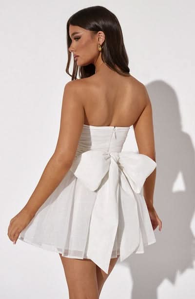 Back view white strapless mini dress with bow tie detail and full skirt