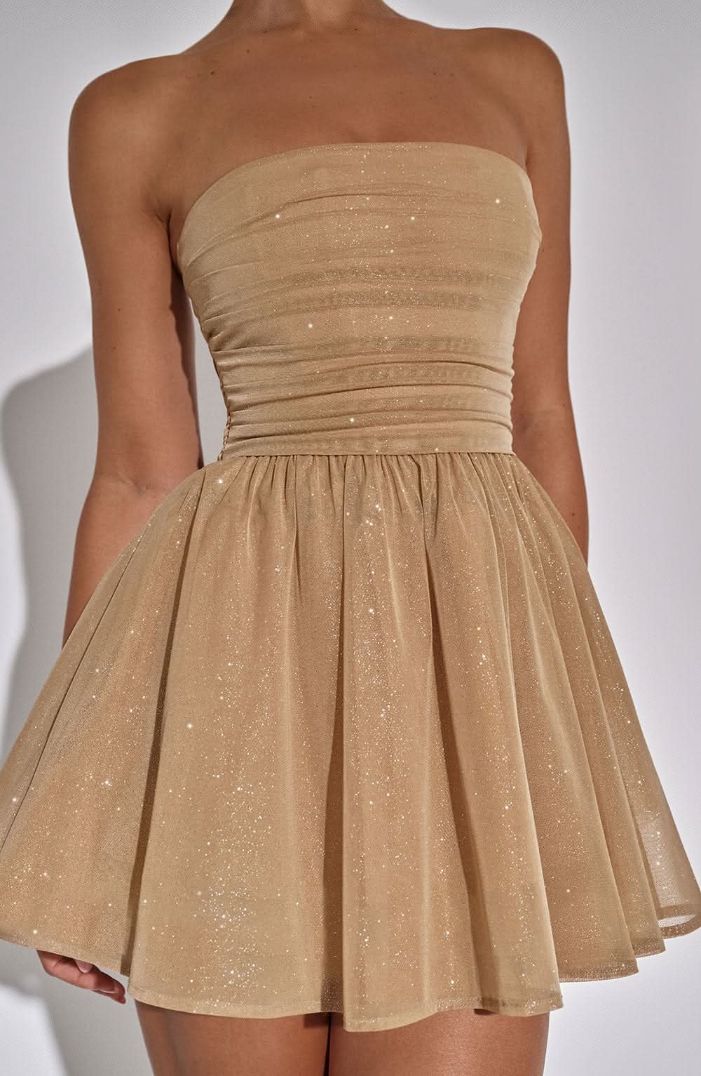 Close-up detail of gold sparkle strapless mini dress bodice and skirt