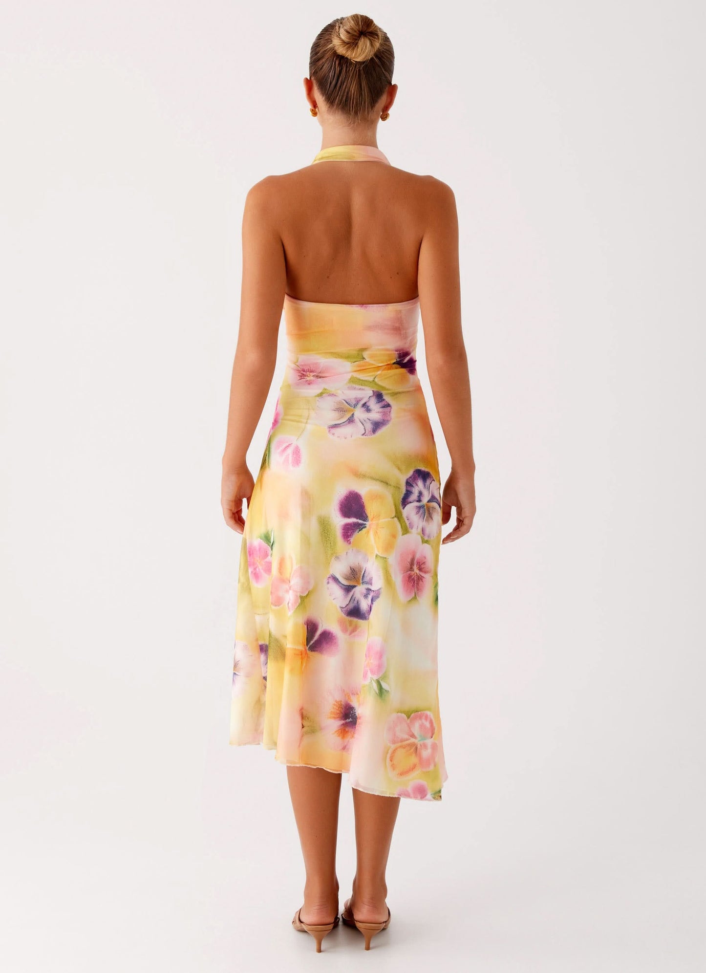 Back view of halter midi dress showing open back and floral skirt detail