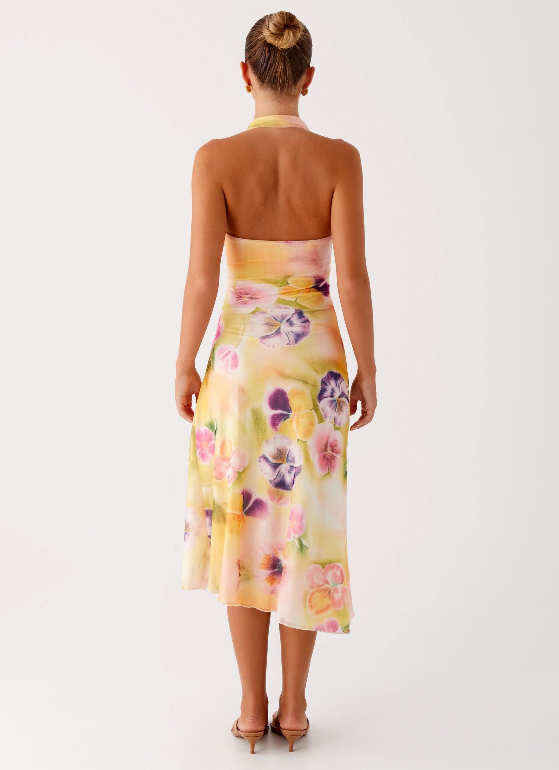 Back view of halter midi dress showing open back and floral skirt detail