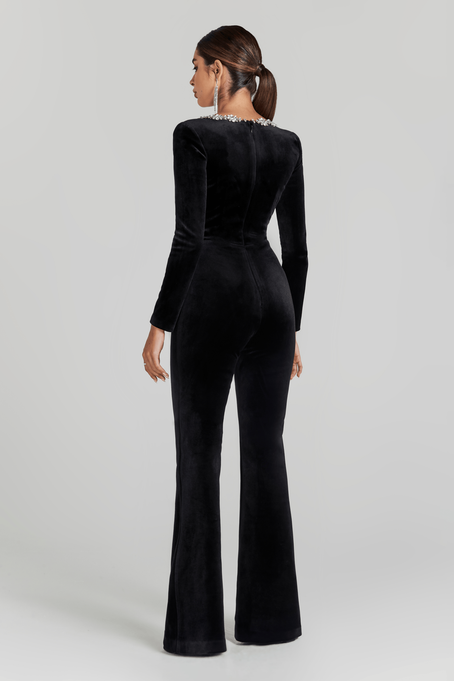 Back view of black velvet jumpsuit with long sleeves and flared pants