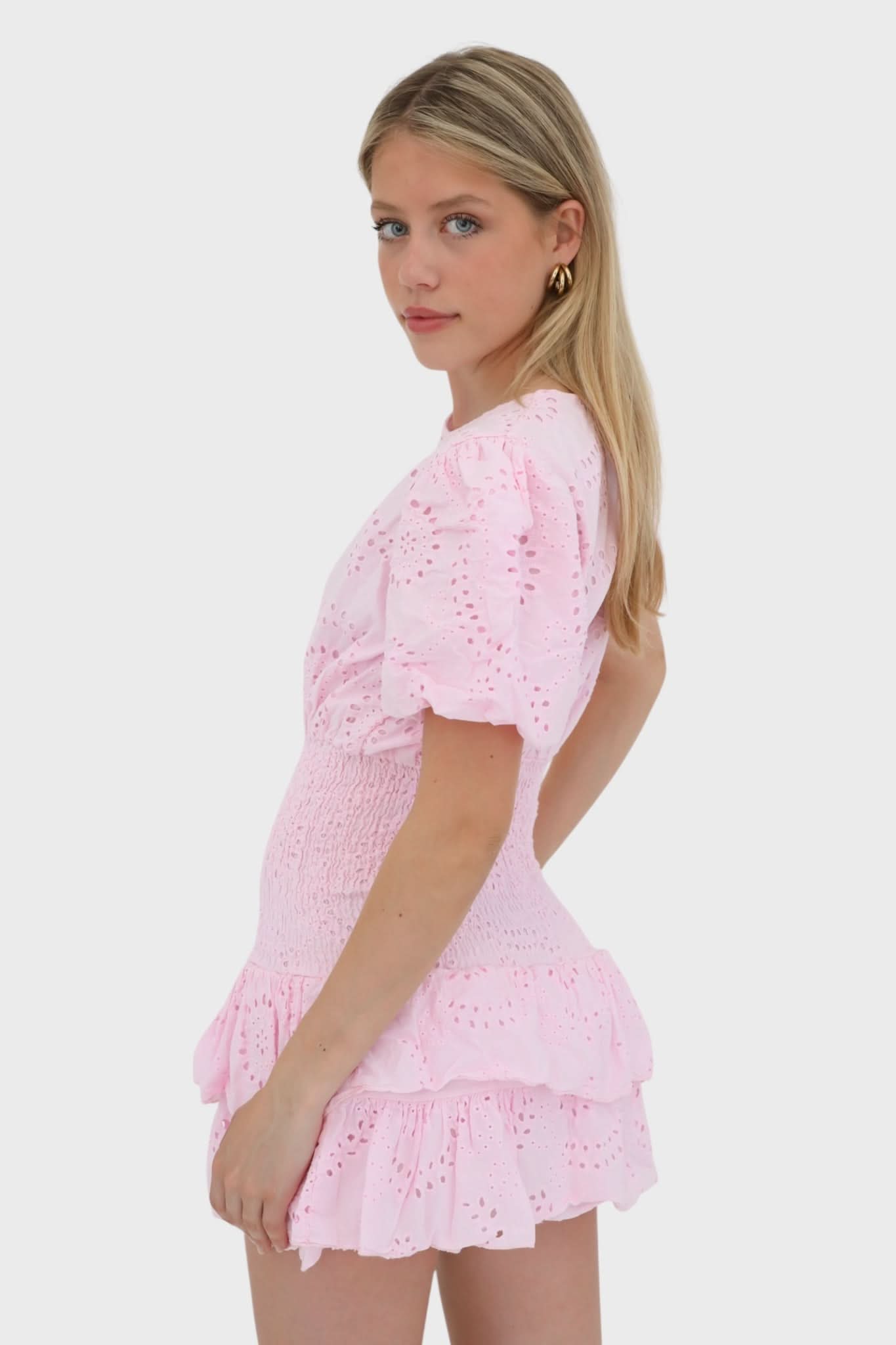 Pink eyelet mini dress with short puffed sleeves and layered ruffled hem