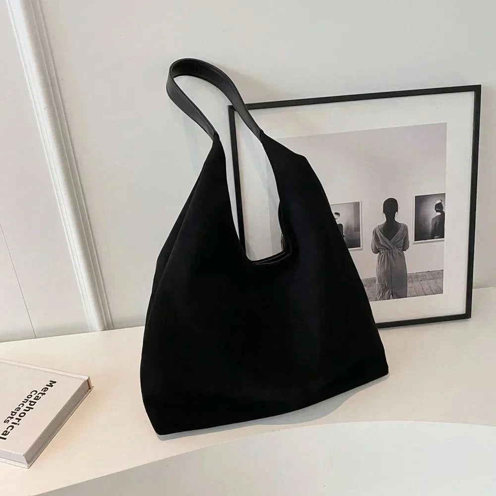 Black suede tote bag with long shoulder straps and spacious interior