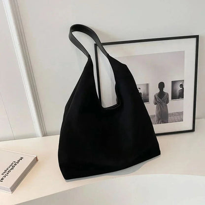 Black suede tote bag with long shoulder straps and spacious interior
