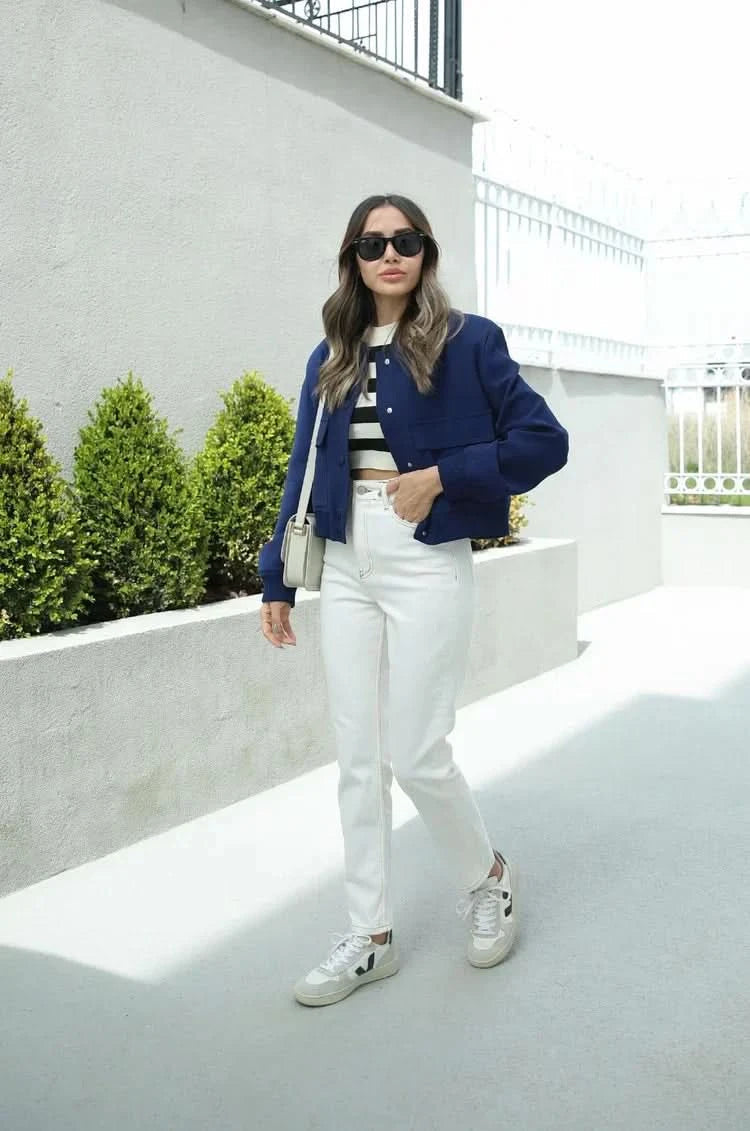 Navy bomber jacket styled with striped shirt and white pants