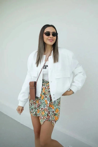 White bomber jacket with snap buttons and floral print skirt