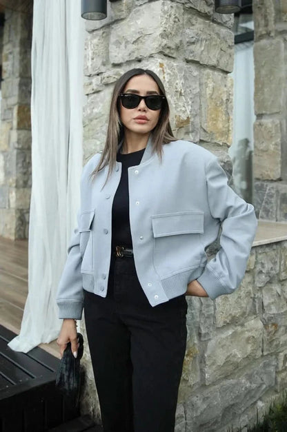 Light gray bomber jacket with button front and black pants