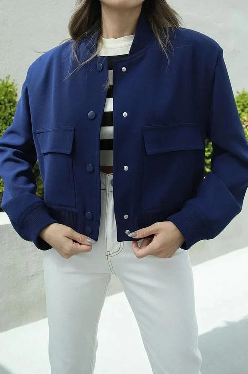 Navy blue bomber jacket with button front and ribbed cuffs worn open