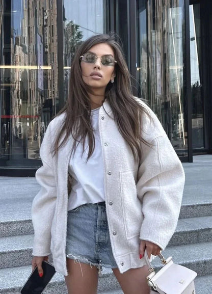 Olive green oversized bomber jacket with textured fabric, worn with black pants
