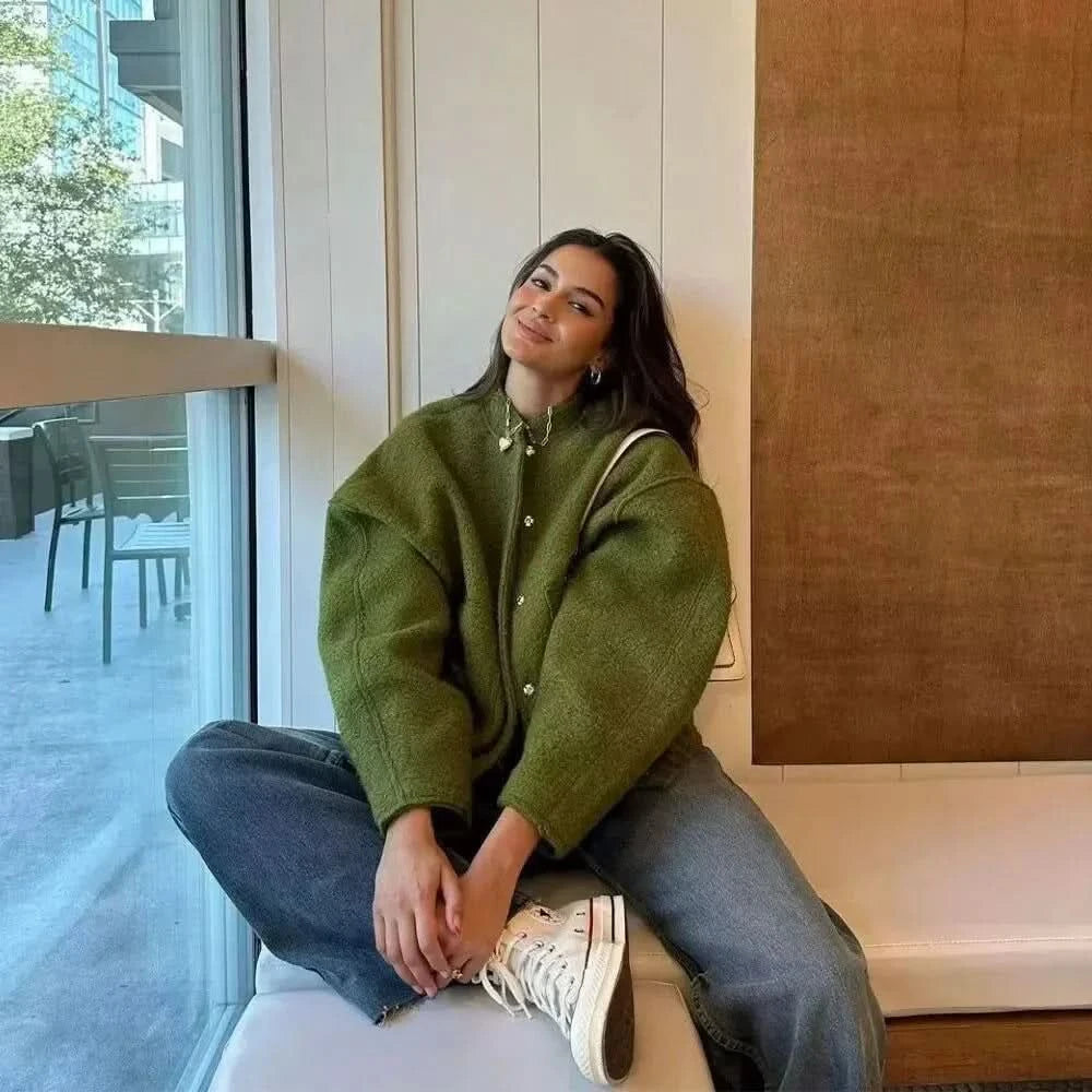 Olive green oversized bomber jacket paired with denim, casual street style
