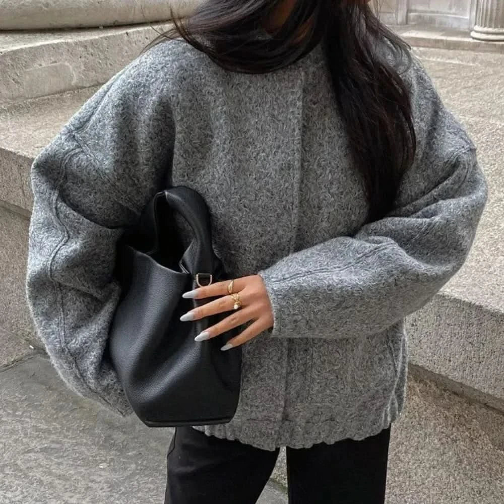 Gray oversized bomber jacket with quilted shoulders and button front
