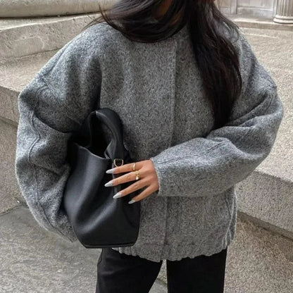 Gray oversized bomber jacket with quilted shoulders and button front