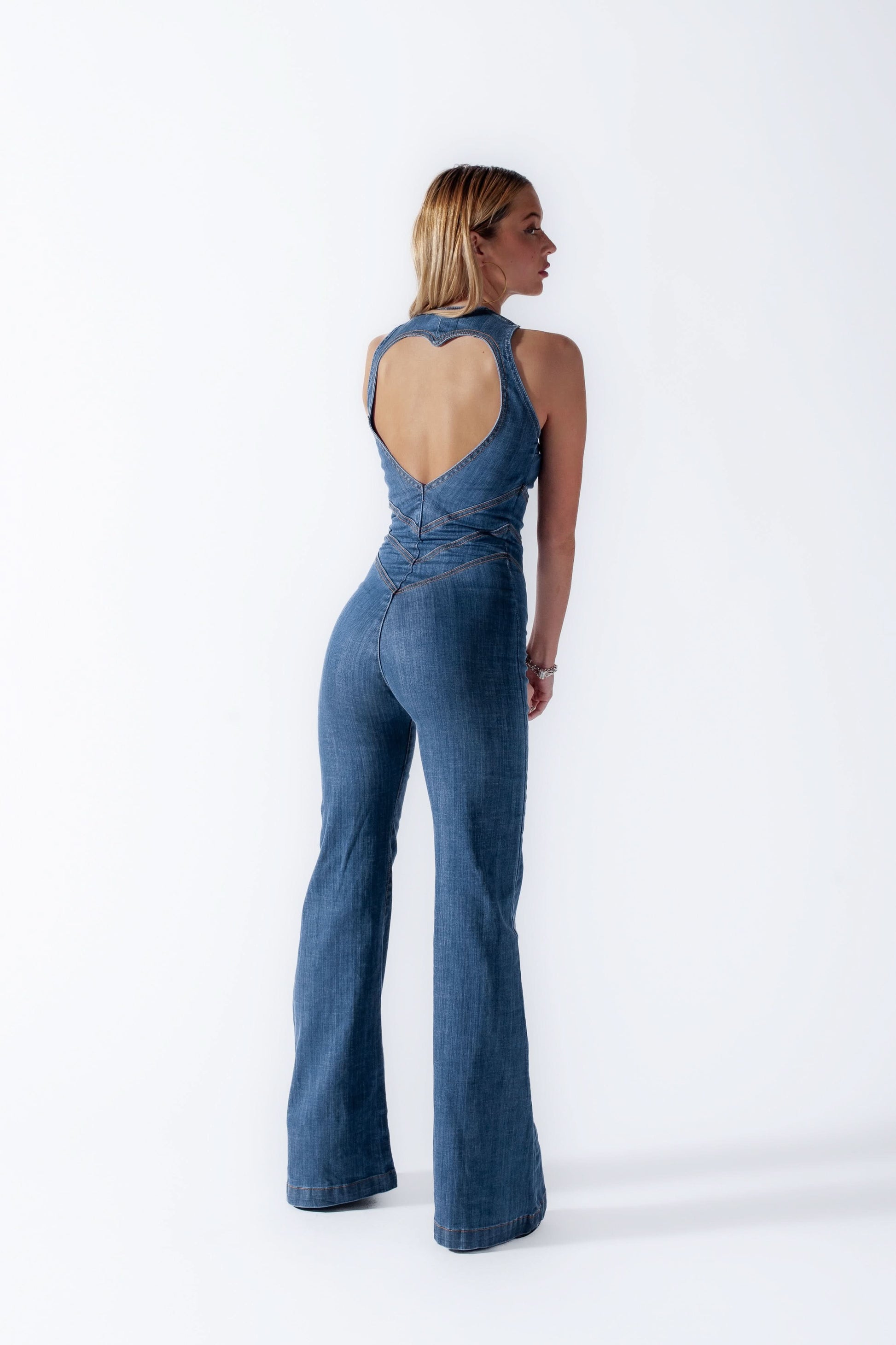 Back view of denim jumpsuit with heart cutout and flared pant legs