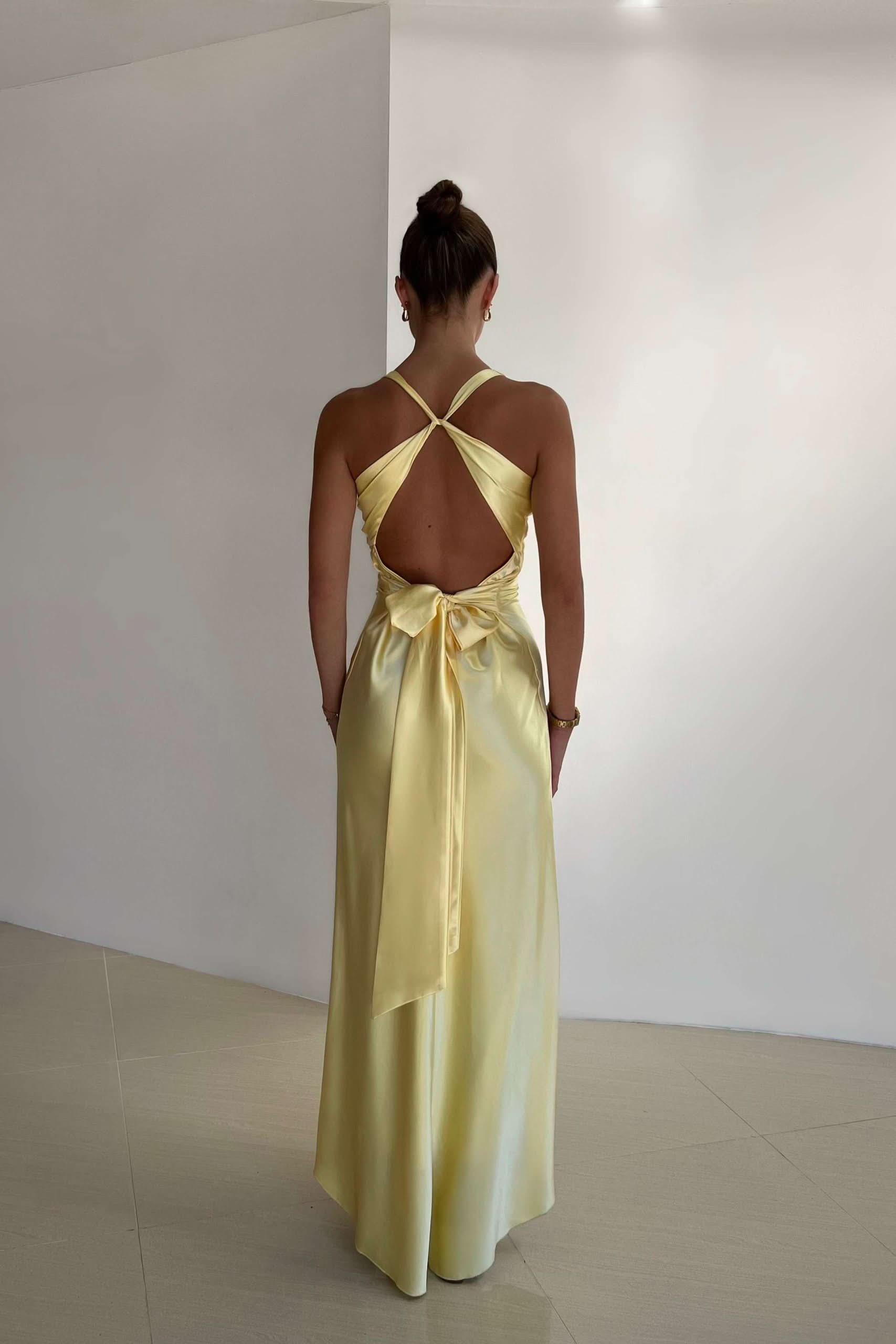 Back view of yellow maxi dress with open back and tie waist detail