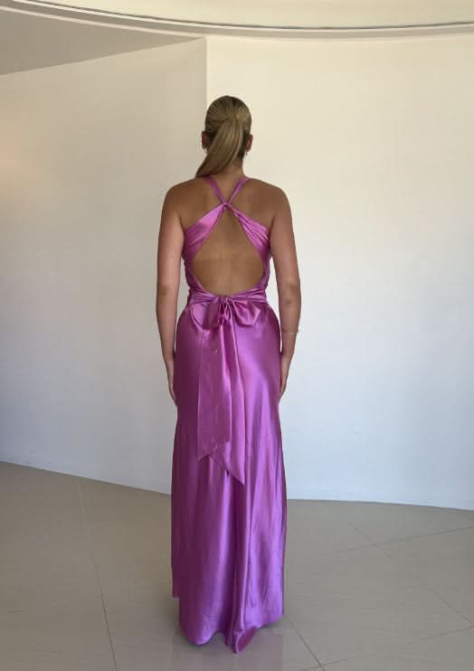 Back view of magenta maxi dress showing open back design with bow
