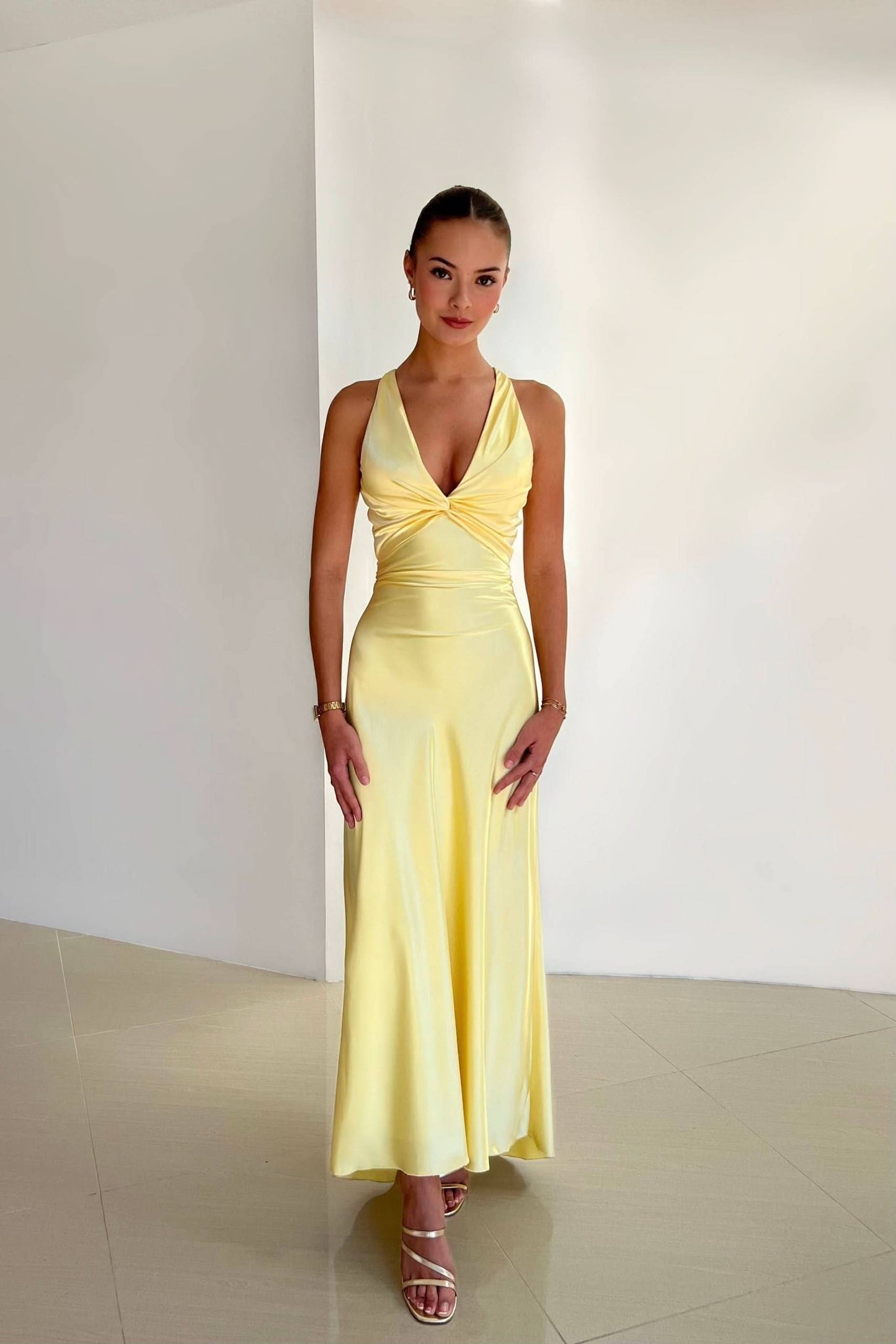 Yellow halter maxi dress with twisted front detail and flowing skirt