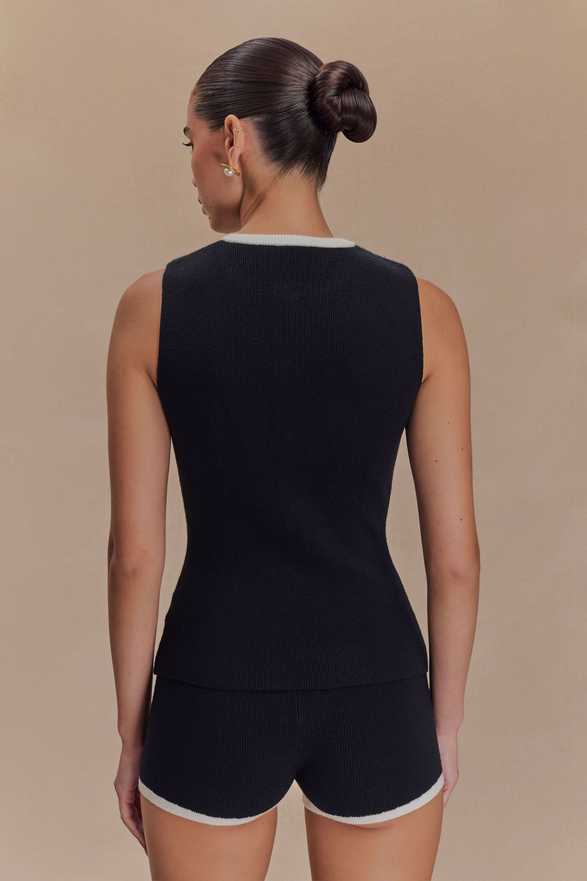 Back view of sleeveless black knit tank with white crew neckline