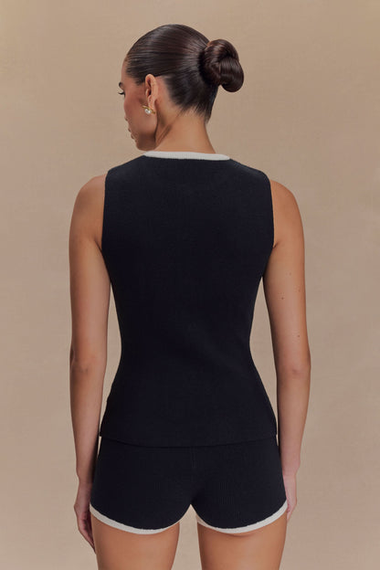 Back view of sleeveless black knit tank with white crew neckline