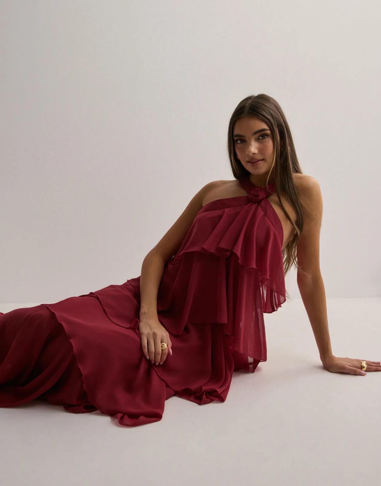 Burgundy halter maxi dress with rosette neckline and cascading tiered ruffles