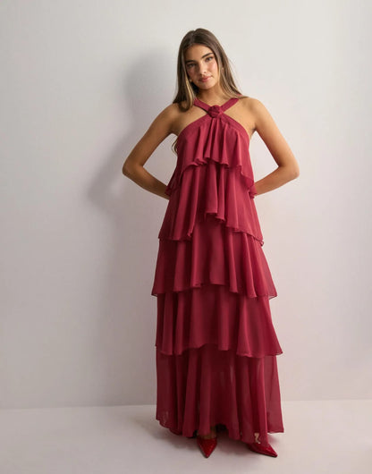 Yellow halter maxi dress with ruffled layers in outdoor field setting