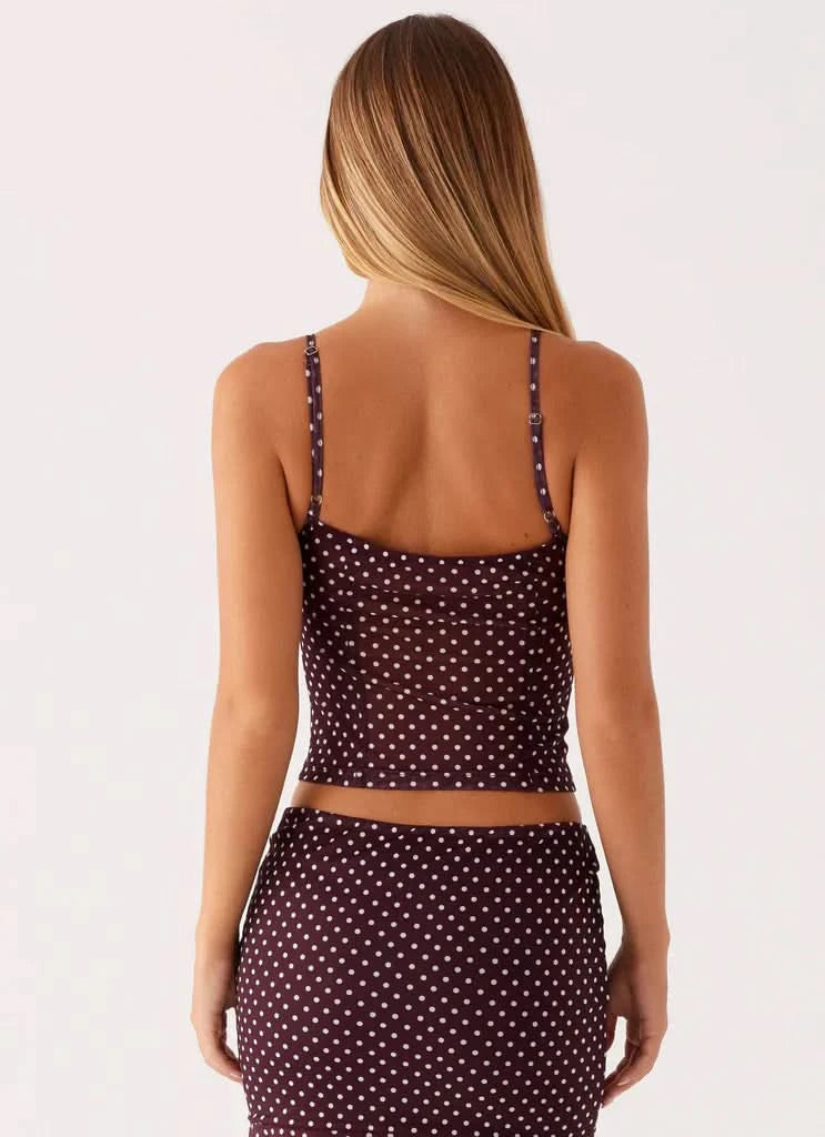 Back view of burgundy polka dot crop top with thin straps