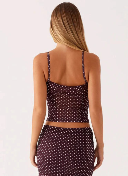 Back view of burgundy polka dot crop top with thin straps