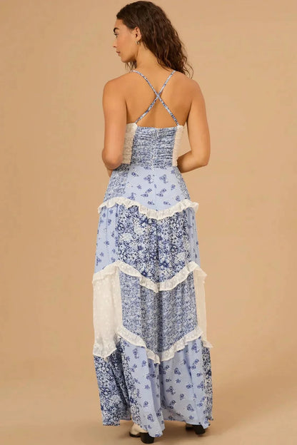 Back view of blue floral maxi dress with cross-back straps and cream ruffled tiers