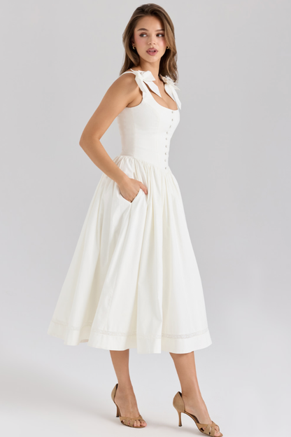 Side view of cream midi dress with fitted bodice and side pockets for women