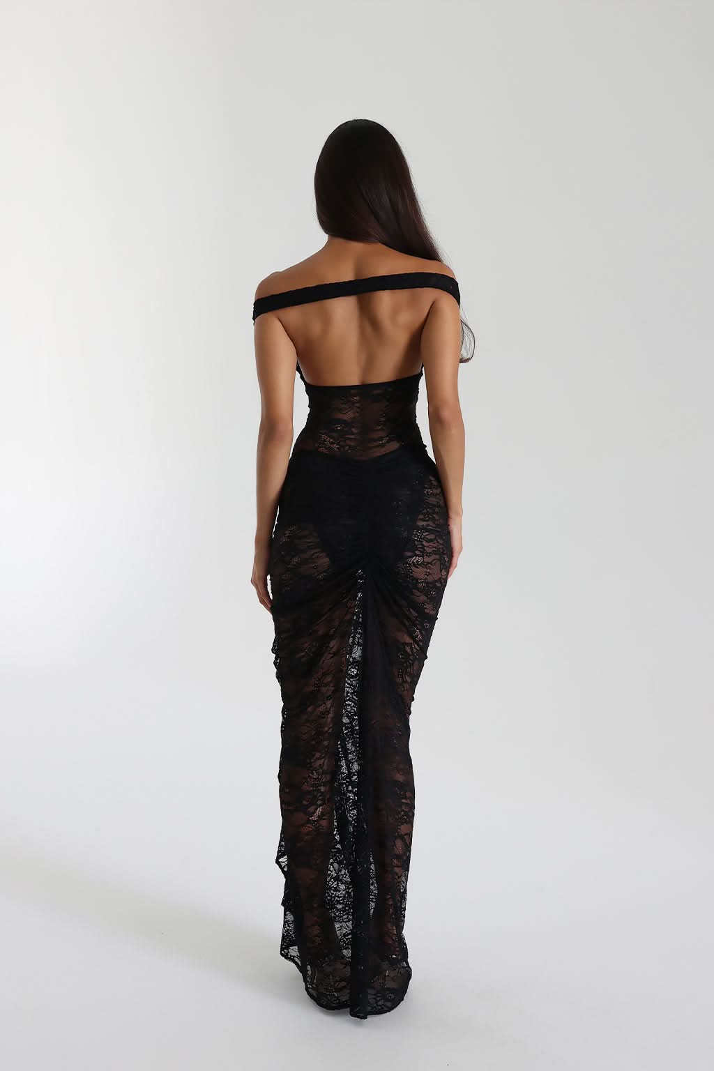 Back view of black lace maxi dress with off-shoulder strap and ruched skirt