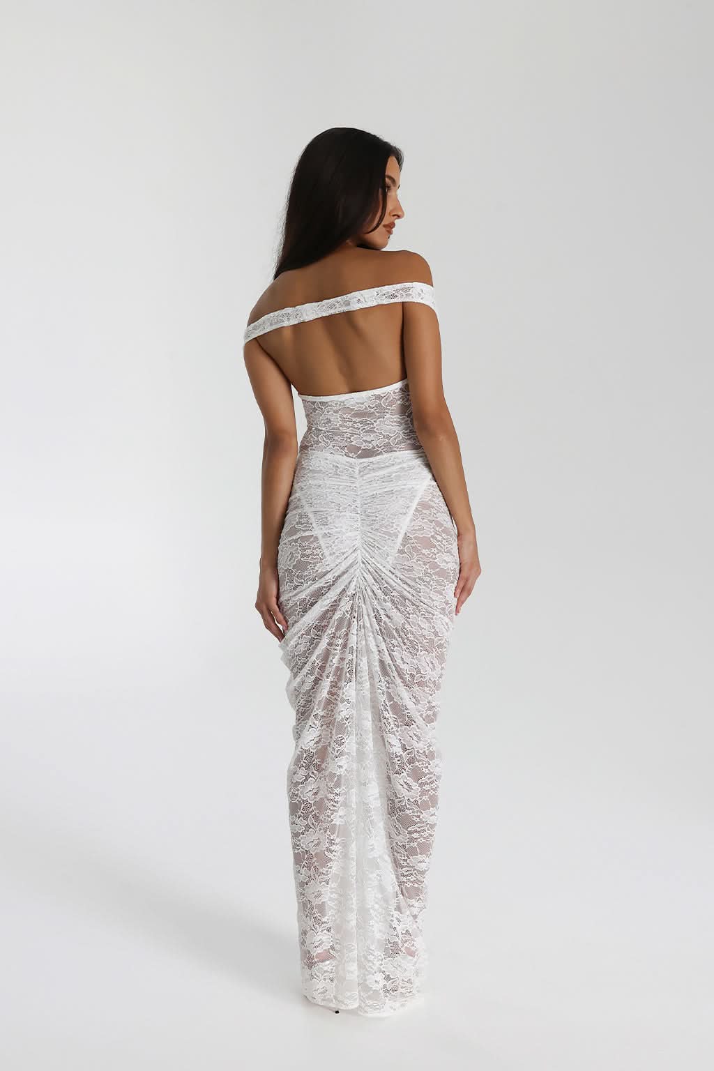 Back view of white lace evening gown with off-shoulder design and draped skirt