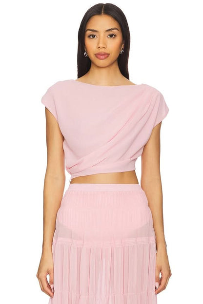 Close-up of pink draped crop top with twisted detail and pleated maxi skirt