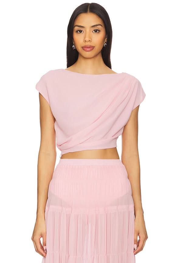 Close-up of pink draped crop top with twisted detail and pleated maxi skirt