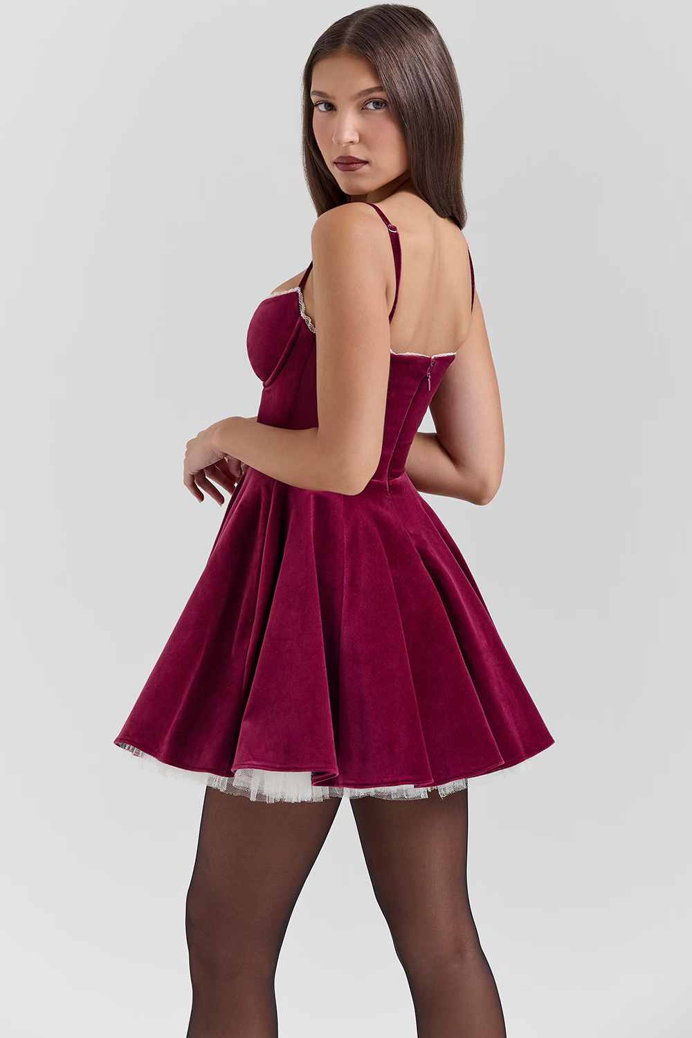 Back view of burgundy velvet mini dress showing open back and zip closure