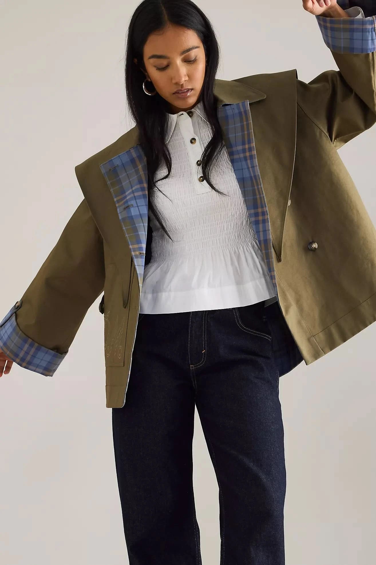 Reversible trench coat open to reveal blue plaid interior lining