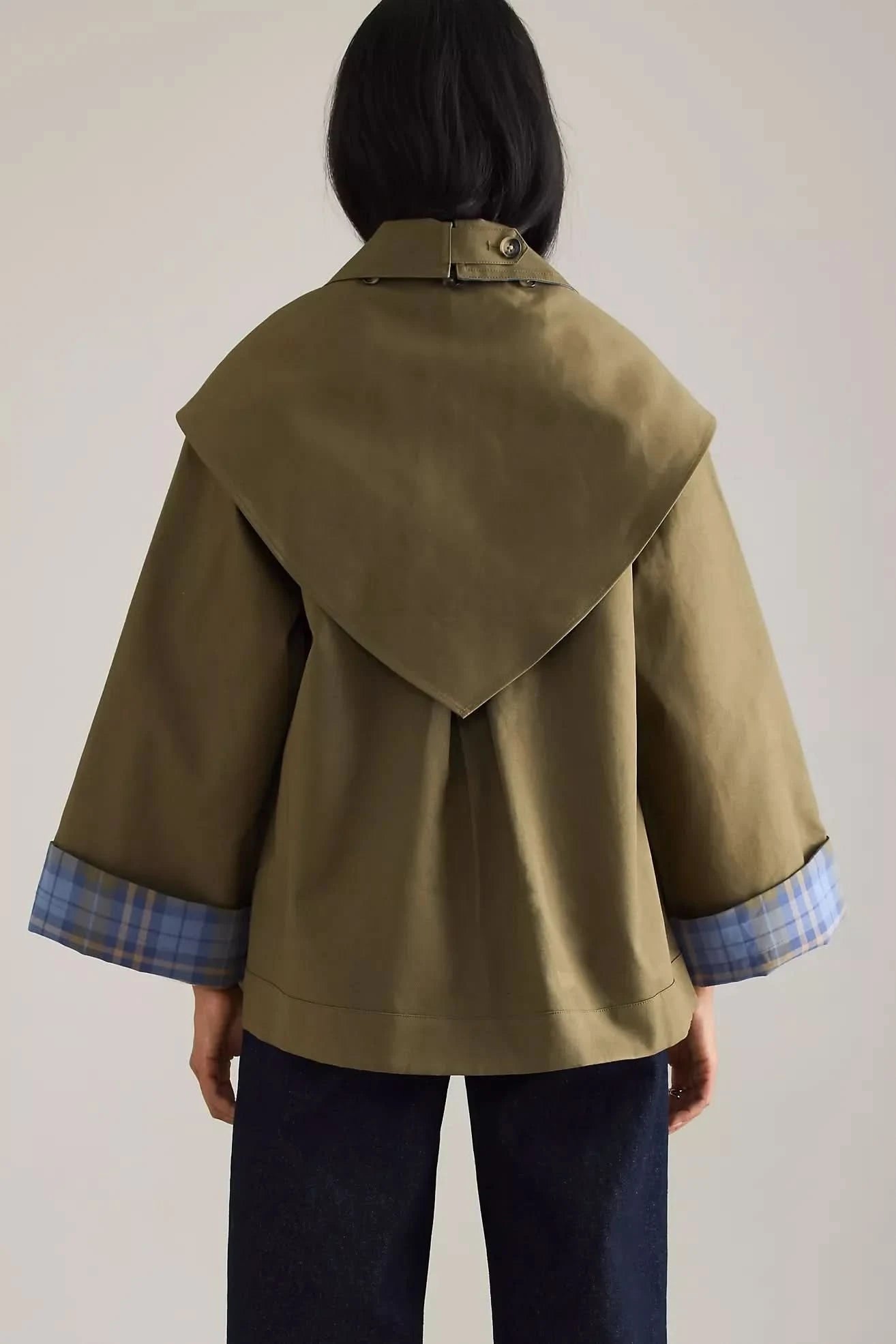 Back view of olive trench coat with blue plaid cuff details