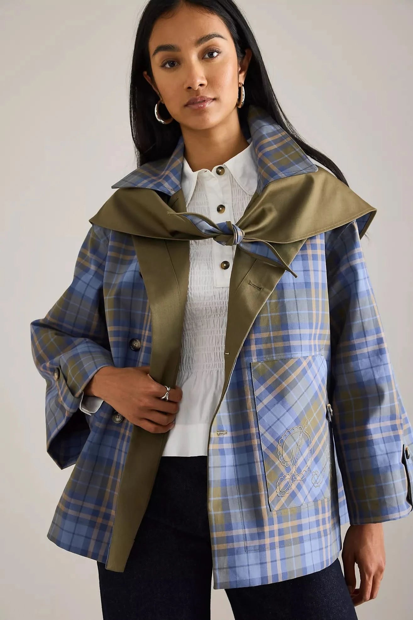 Reversible trench coat worn with plaid side showing, tied collar detail