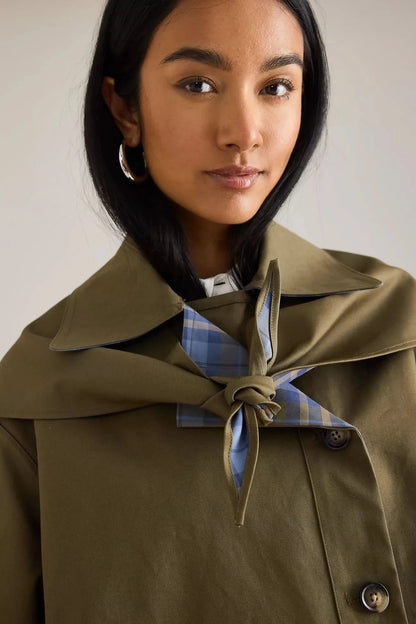 Close-up of reversible trench coat collar and tie detail with plaid lining