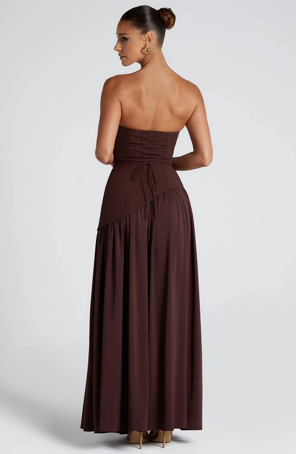 Brown strapless maxi dress back view with asymmetrical pleated skirt