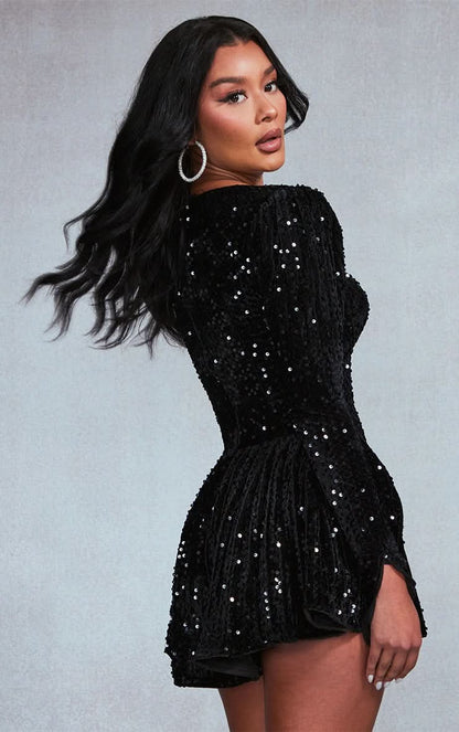 Back view of black sequin mini dress with long sleeves and flared skirt