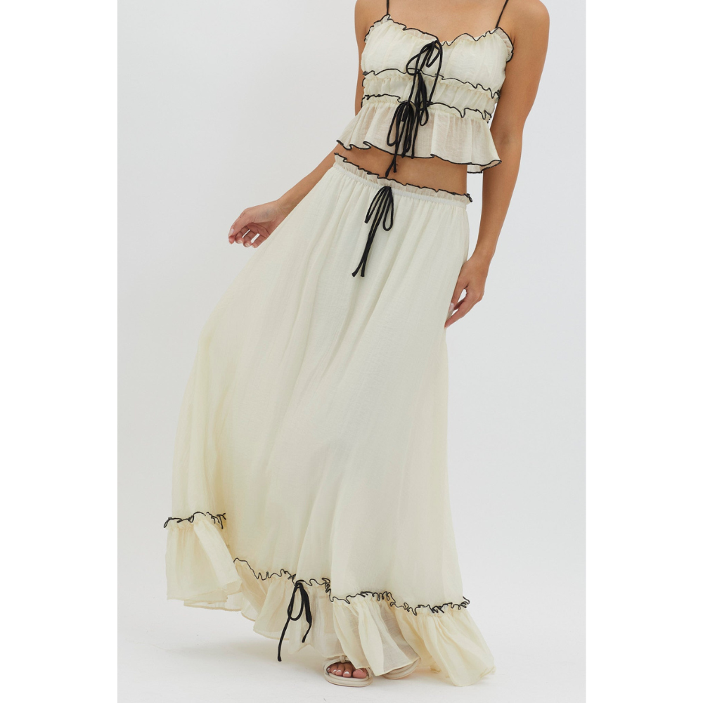 Close-up of cream maxi skirt set showing ruched details and black drawstring accents